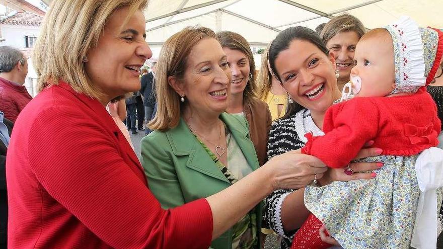 Fátima Báñez y Ana Pastor juegan con la hija de Nidia Árevalo, ayer, en Mos. // M.G. Brea