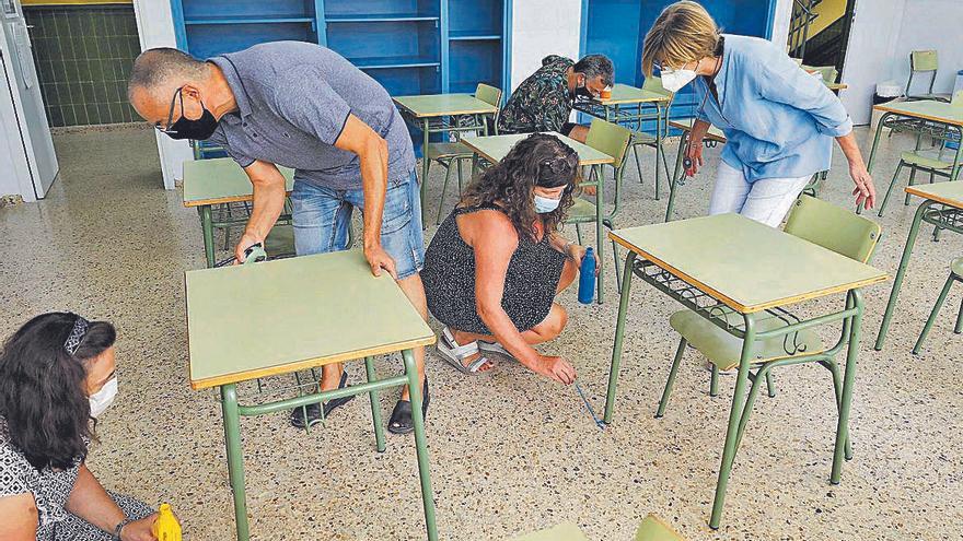 Un grupo de profesores preparan un aula con todas las medidas de seguridad.