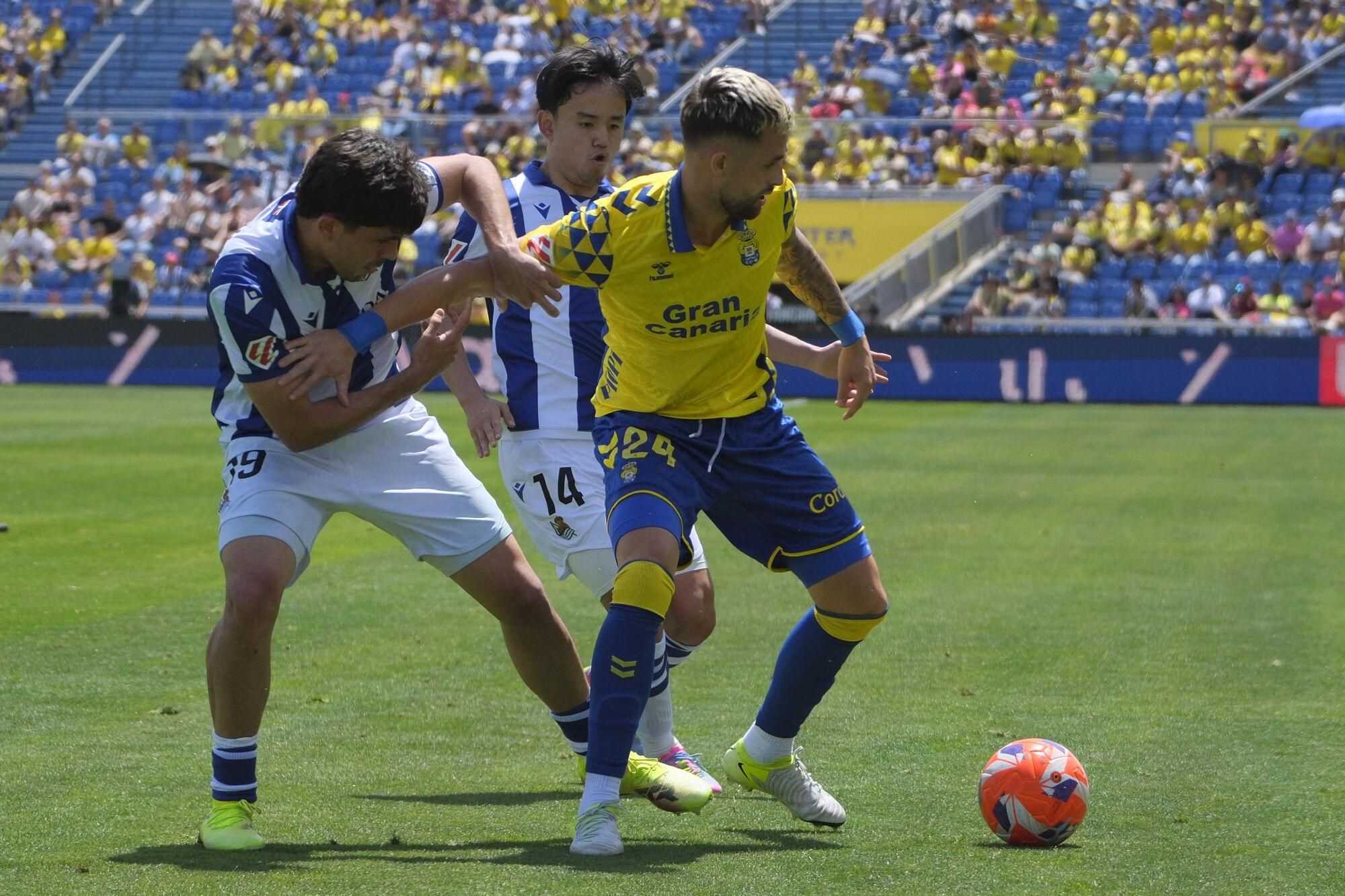 LAS PALMAS DE GRAN CANARIA, 06/04/2025.- El defensa de la Real Sociedad Jon Aramburu (izda) y el centrocampista Takefusa Kubo, pelean por el control del balón ante el jugador de la UD Las Palmas, Adnan Januzaj, durante el partido de LaLiga disputado este domingo en el estadio de Gran Canaria en Las Palmas. EFE/Ángel Medina G.