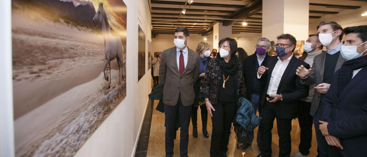 Víctor Cucart, en el centro de la imagen, explica una de sus fotografías a las autoridades locales.           àlex oltra