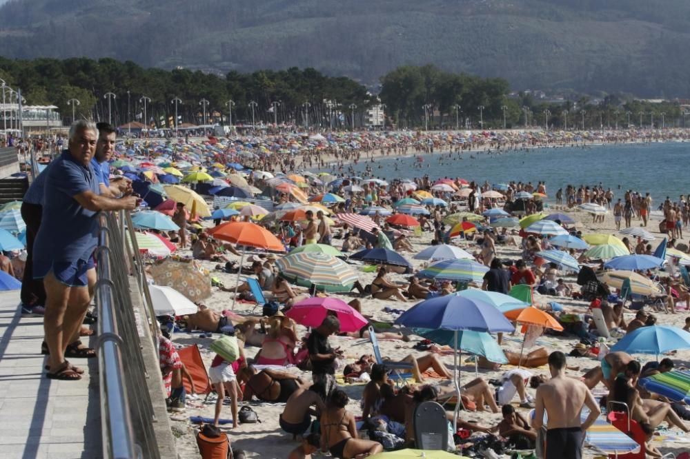 El buen tiempo anima a los bañistas en la playa de Samil