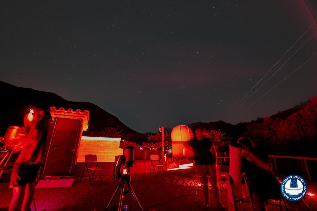 Diverses persones observant amb telescopis el cel fosc d'Albanyà