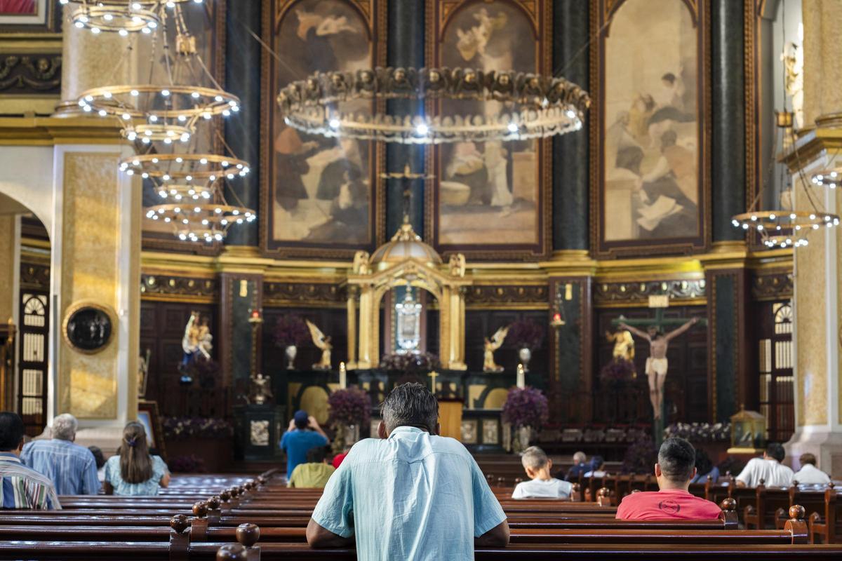 Varias personas rezando en la catedral de San Salvador.