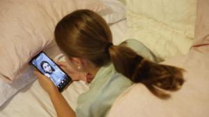 Una adolescente mira vídeos de TikTok en su habitación.