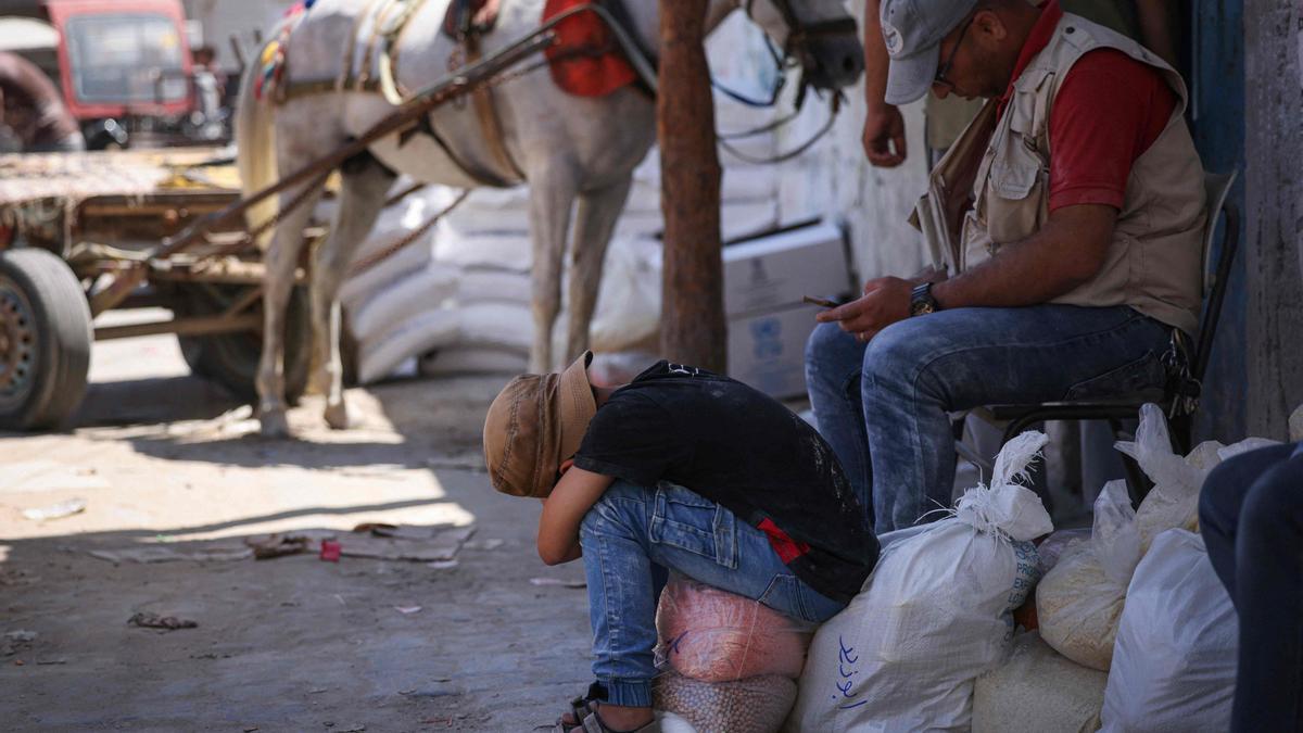 Un  niño palestino descansa sobre una bolsa de comida proporcionada por el PMA.