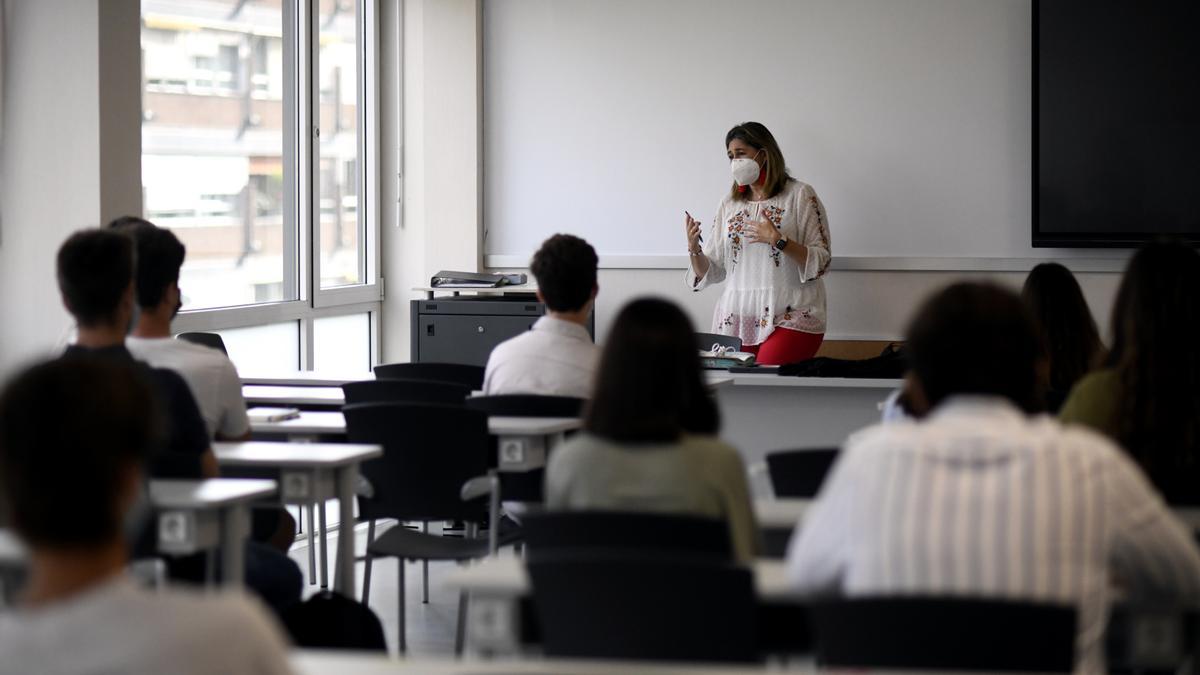 Una profesora da clase con mascarilla. Recurso.