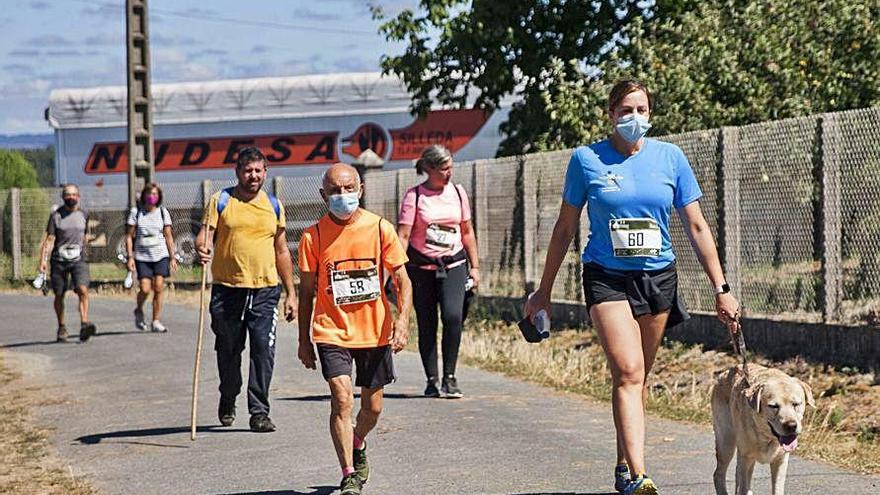 Un grupo de participantes en la prueba en la salida de Breixa y otro de caminantes durante la ruta pedestre.