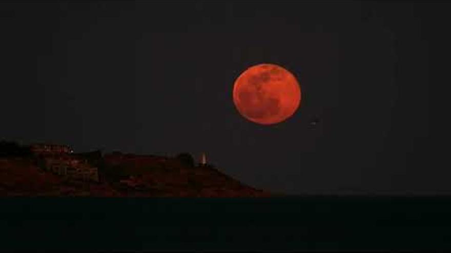 Una luna llena tras el faro da la bienvenida a la primavera en Alicante