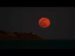 Una luna llena tras el faro da la bienvenida a la primavera en Alicante