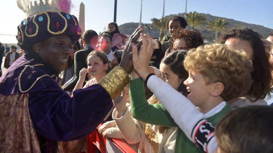 El Rey Baltasar saluda a un niño antes de la Cabalgata del pasado año.