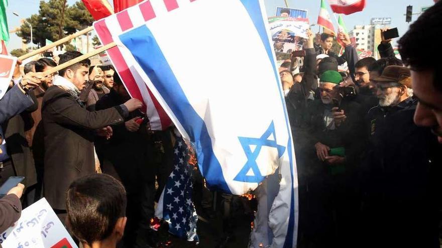 Manifestantes progubernamentales queman banderas estadounidenses e israelíes, ayer en la ciudad iraní de Mashhad.