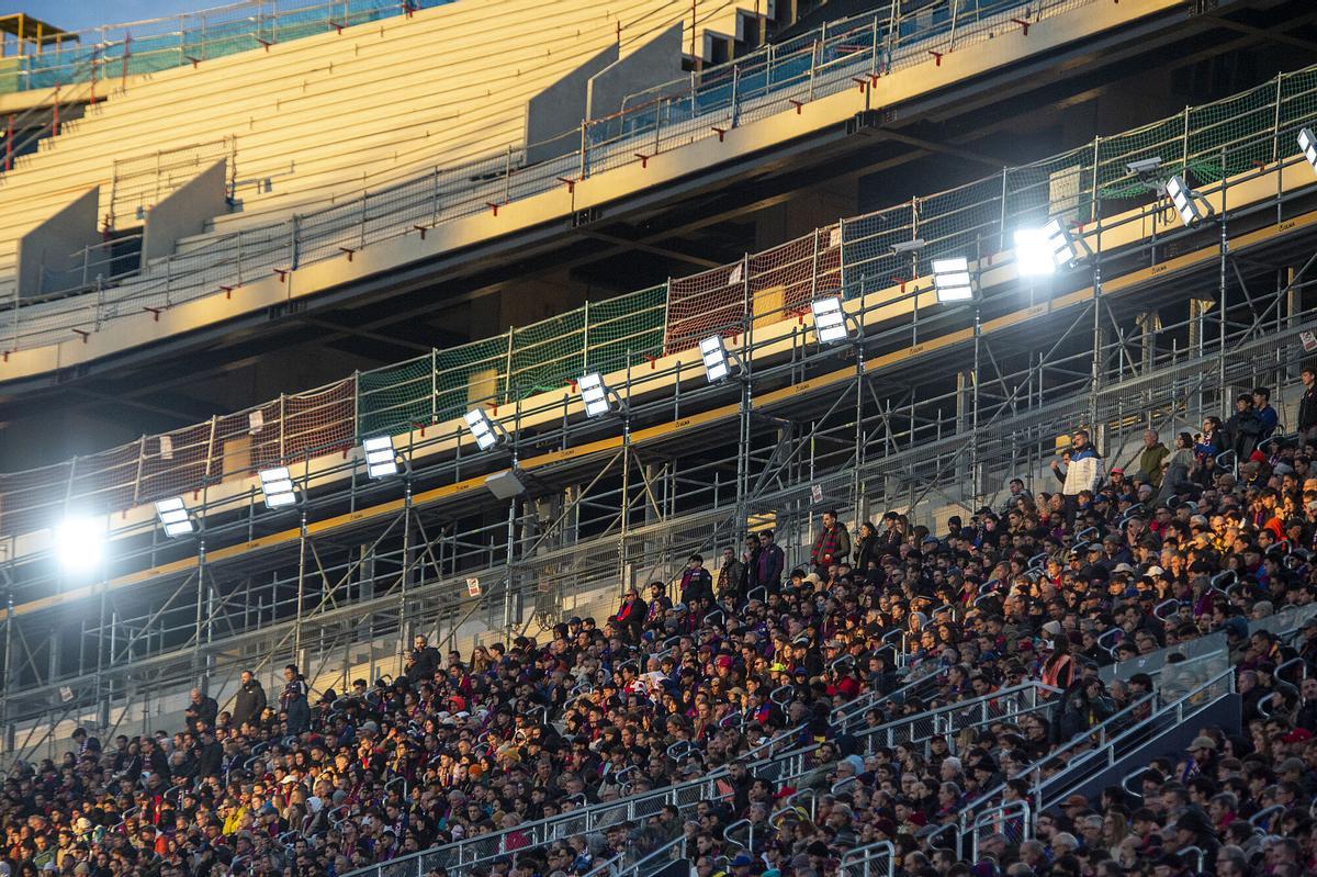 Los aficionados ocupan parte de la grada lateral mientras se construye al tercera gradería.