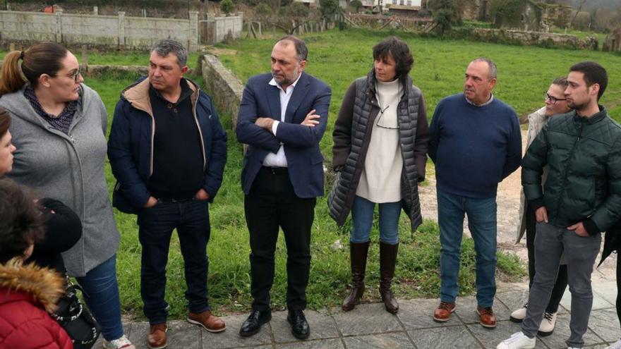 El conselleiro, en el centro, con la finca de Parga tras él.