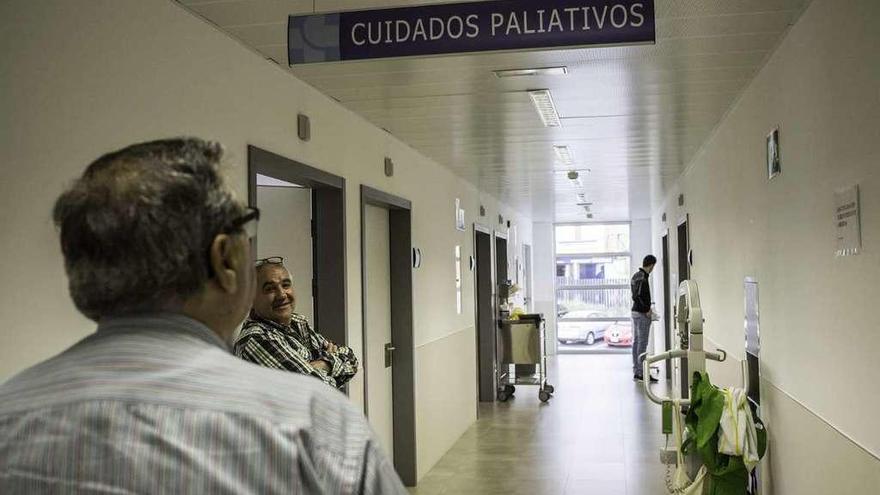 Un hombre observa el cartel de cuidados paliativos en el Hospital tras su colocación.