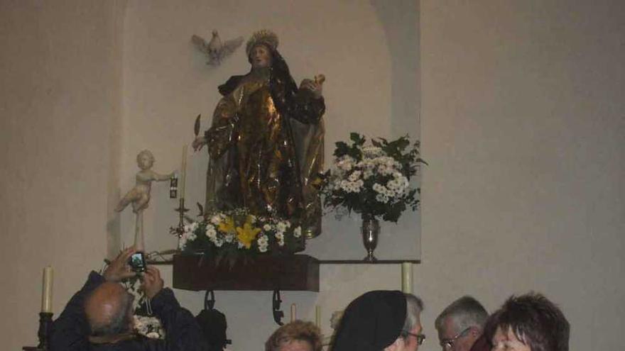 Vecinos conversan en el convento ante una talla de santa Teresa.