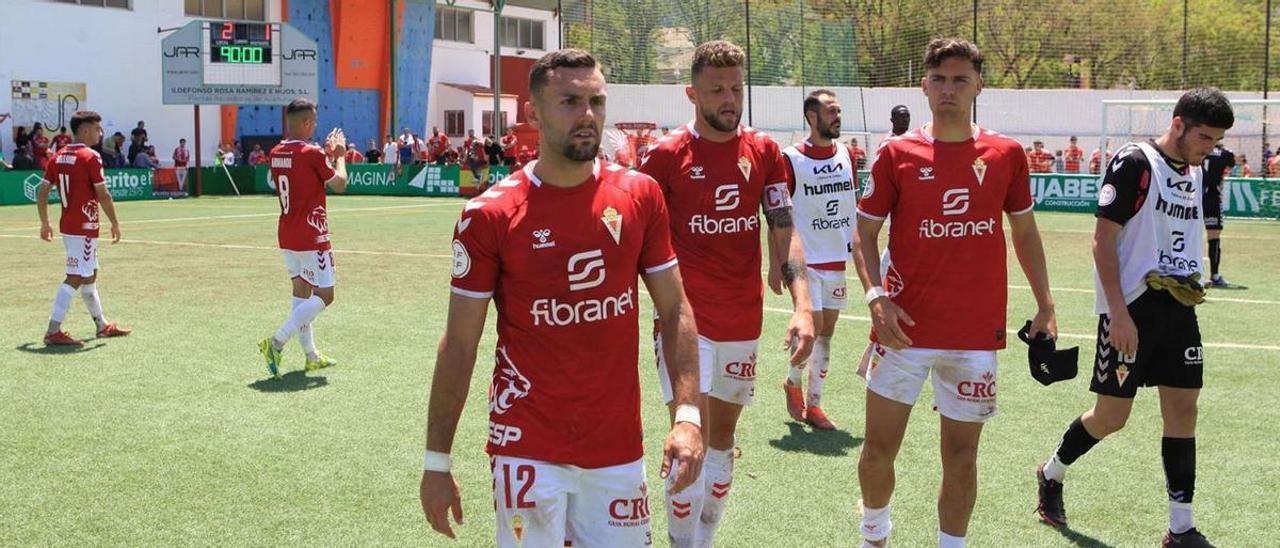 Los jugadores granas abandonan el campo del Mancha Real con rostros serios tras la derrota y la caída al cuarto puesto. | PEPE VALERO