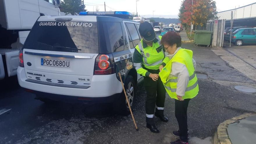 Una agente coloca un chaleco a una mujer. // GC