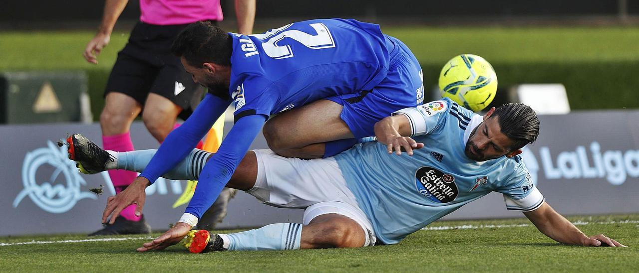 Nolito intenta frenar desde el suelo el avance del lateral del Getafe Iglesias. // RICARDO GROBAS