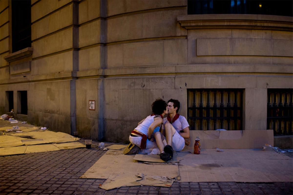 Una parella es besa al final de la festa en un carrer de Pamplona. (AP / DANIEL OCHOA DE OLZA)