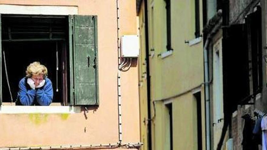 Una dona mirant per la finestra durant la quarantena a Itàlia
