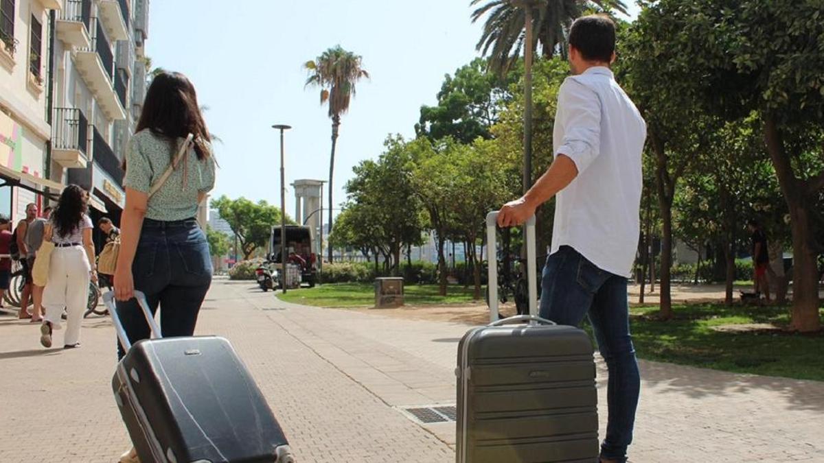 Turistas transitan con sus maletas por Málaga capital.