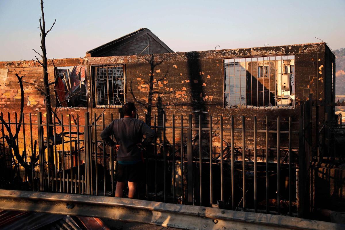 Un hombre observa una casa quemada luego de un incendio que afectó los cerros de Viña del Mar, Chile, el 3 de febrero de 2024. La región de Valparaoso y Viña del Mar, en el centro de Chile, amaneció el sábado con un toque de queda parcial para permitir el movimiento. de evacuados y el traslado de equipos de emergencia en medio de una serie de incendios sin precedentes, informaron las autoridades.