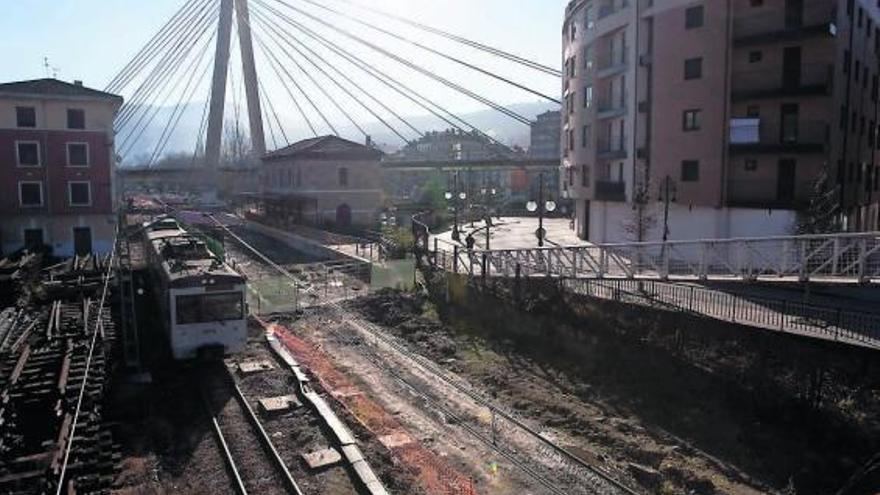 Un tren de Feve, circulando por la zona de Sama afectada por el soterramiento de las vías, en la que no hay actividad.