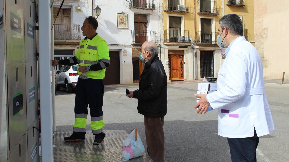 Dos personas depositan sus residuos al ecoparque móvil.