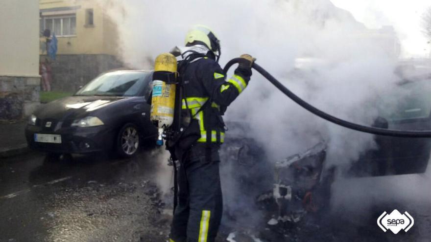 Un bombero, durante la intervención para sofocar el incendio de un turismo en Llaranes.