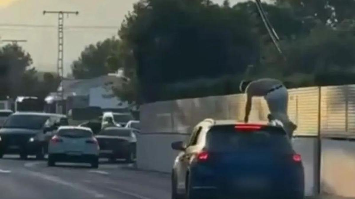 El coche en marcha en Xàbia y el joven subido en el techo