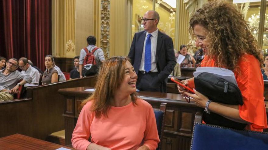 La presidenta, Francina Armengol, conversa con la consellera de Presidencia, Pilar Costa, en el Parlament.