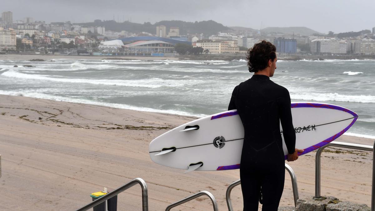 Un surfista observa el mar en el Orzán.