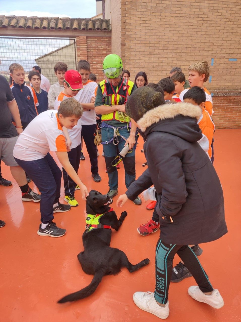 Los escolares con uno de los miembros de la unidad canina que participó en la demostración.