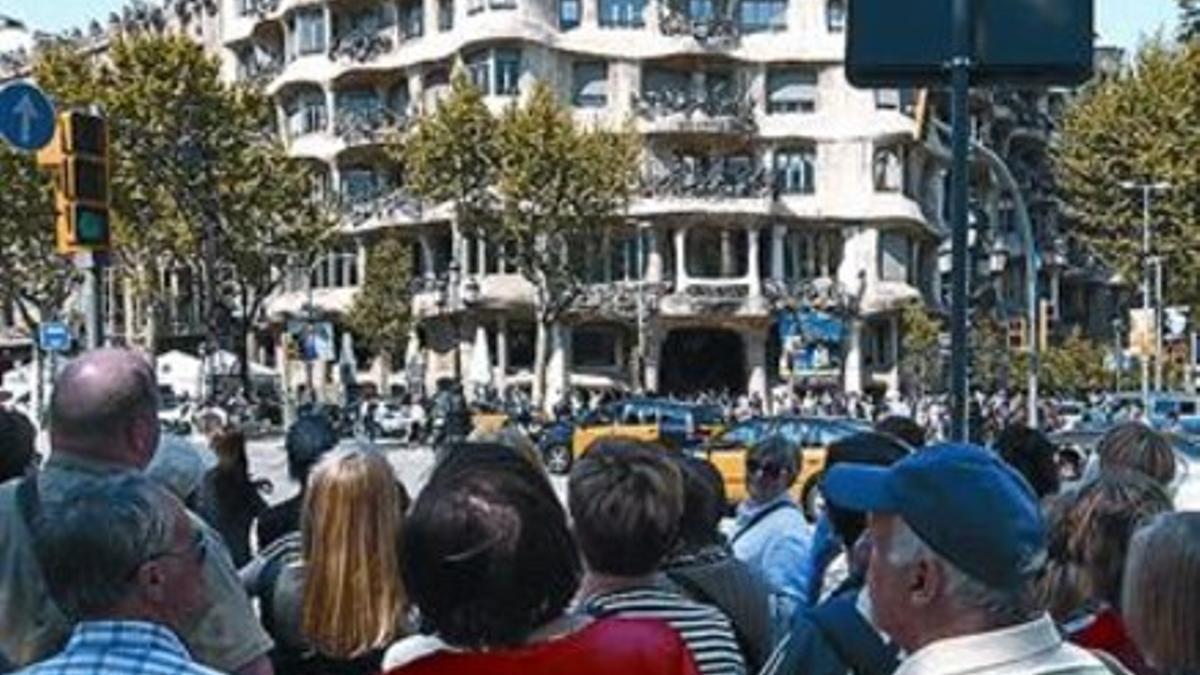 Ante la Pedrera Turistas en el paseo de Gràcia, el día de Sant Jordi.