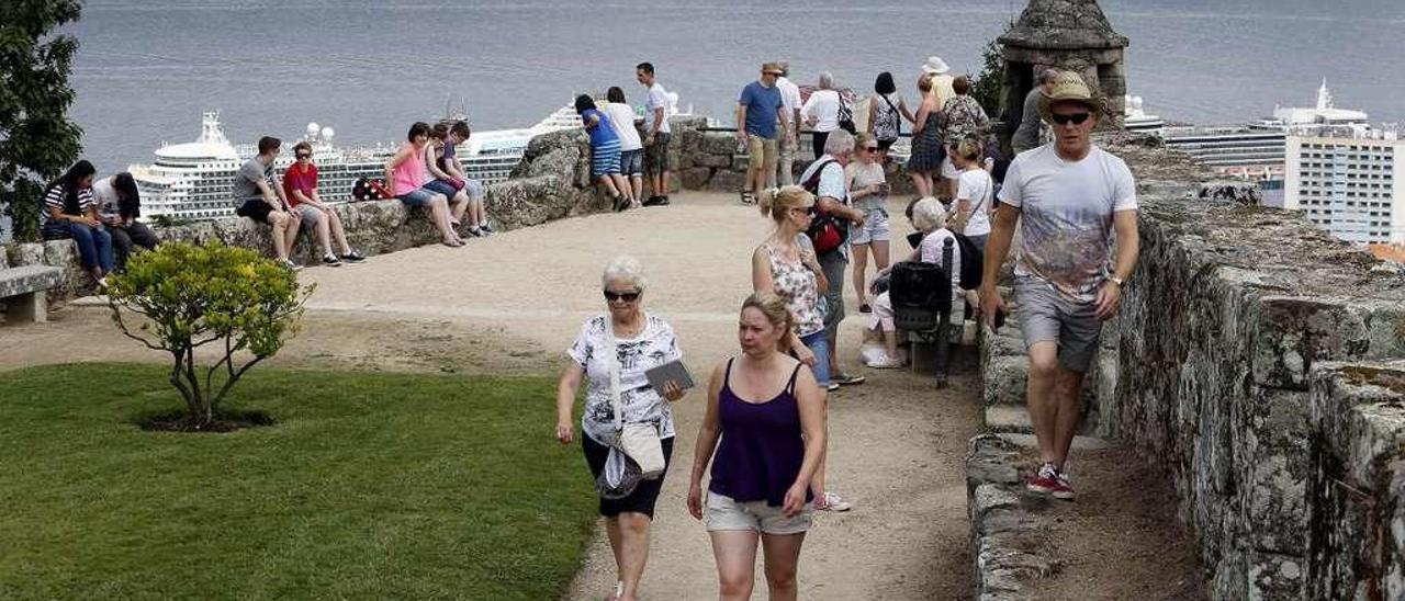 Turistas en O Castro disfrutando de uno de los miradores sobre la Ría. // Marta G. Brea