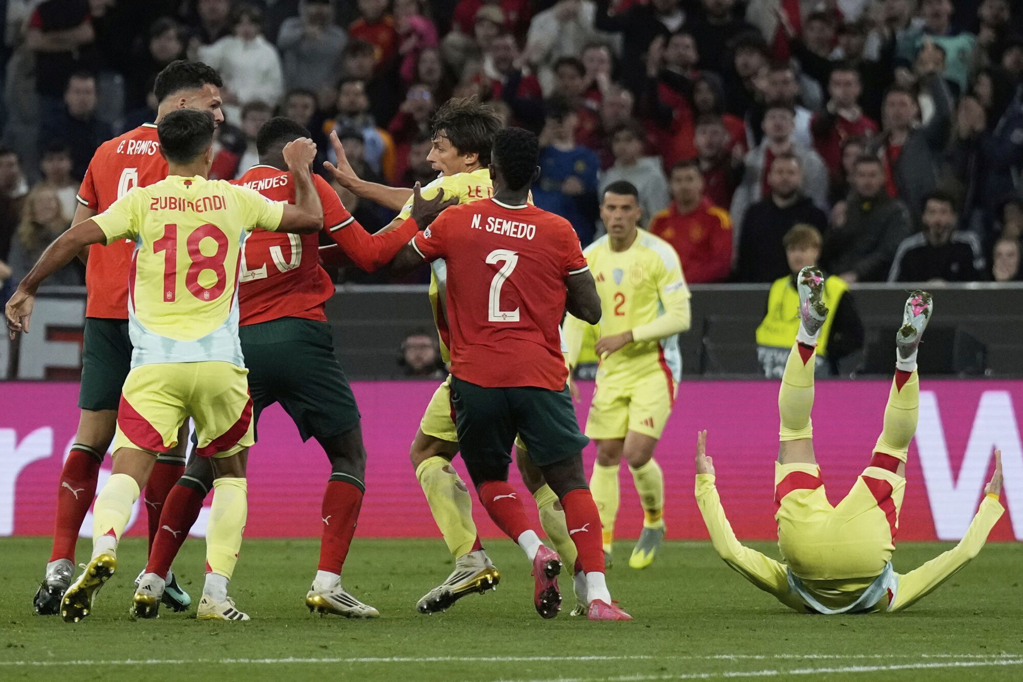 Spain's Alex Baena, right, falls on the pitch during the Nations League final soccer match between Portugal and Spain at the Allianz Arena in Munich, Germany, Sunday, June 8, 2025. (AP Photo/Matthias Schrader). EDITORIAL USE ONLY/ONLY ITALY AND SPAIN