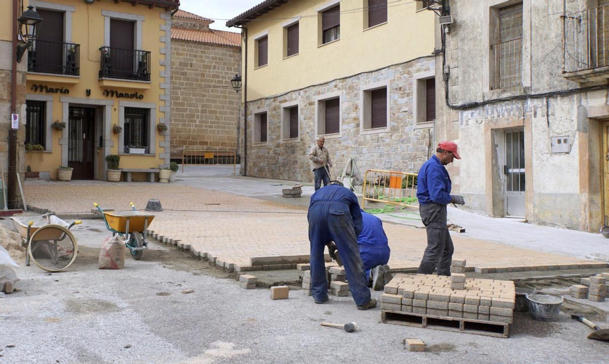 Varios operarios trabajan en la colocación del nuevo adoquinado en vías de Alcañices. | CHANY SEBASTIÁN