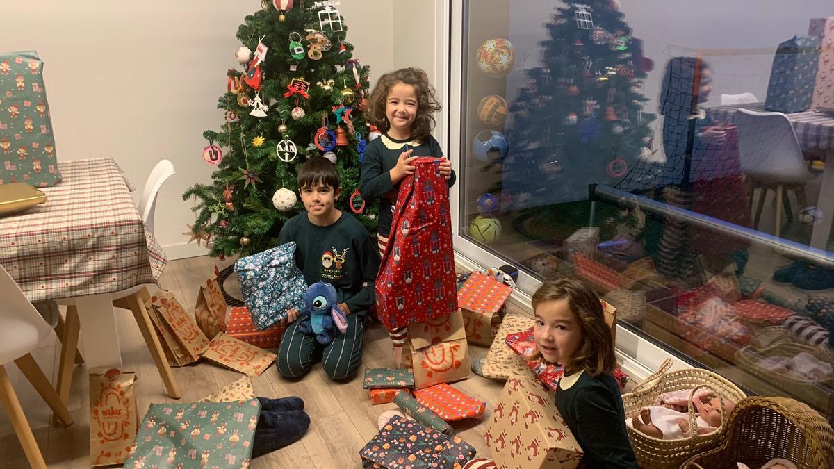 Los compostelanos Xiana, Uxía y Xan Vilas abren sus regalos en la mañana de Reyes