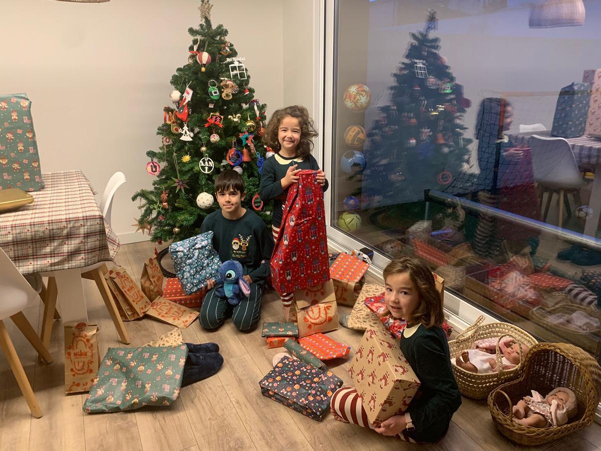 Los compostelanos Xiana, Uxía y Xan Vilas abren sus regalos en la mañana de Reyes