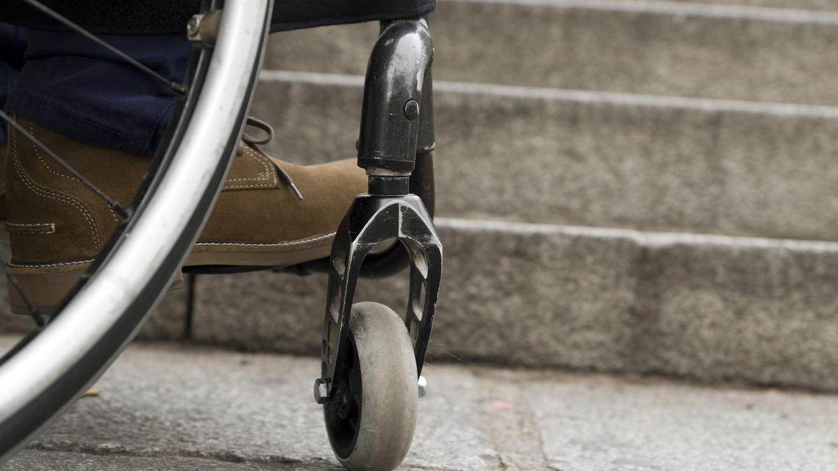 Una silla de ruedas y una escalera sin accesibilidad