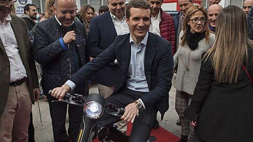 Pablo Casado se sube a un patinete eléctrico ante la mirada de los responsables provinciales del PP.