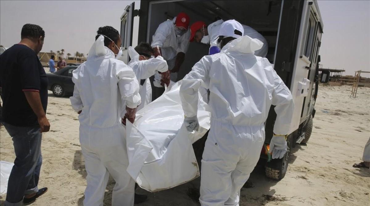 Varias personas recogen los cuerpos sin vida de inmigrantes que han aparecido en una playa en Zuwarah al oeste de Tripoli en Libia.