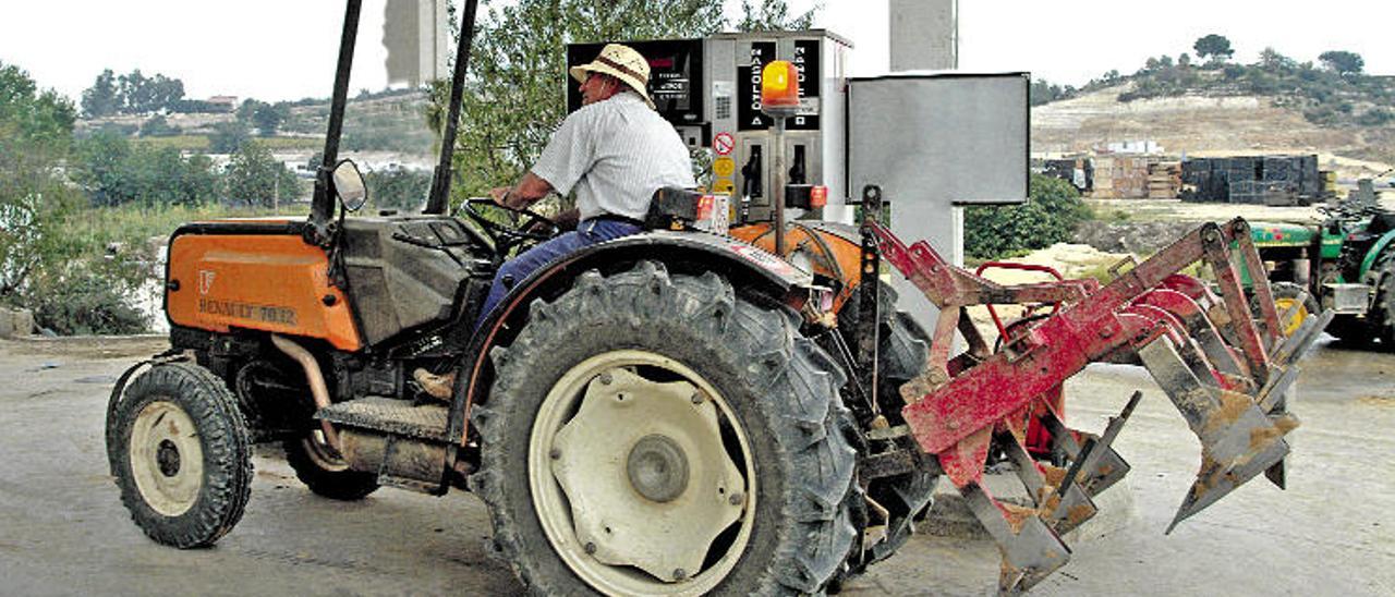 Un agricultor llena el tanque de combustible de su tractor.