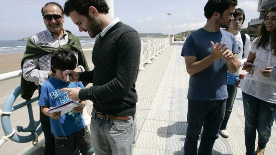 Juan Mata, firmando un autógrafo al niño Nicolás García en el paseo de Salinas ayer por la mañana.m