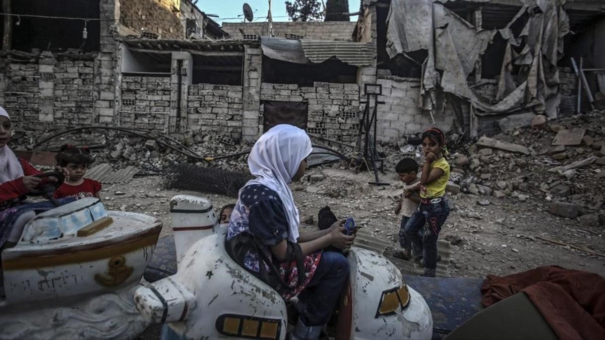 Niños sirios juegan en un carrusel durante el segundo día de la festividad musulmana de Eid Al Adha, en Douma, este martes.