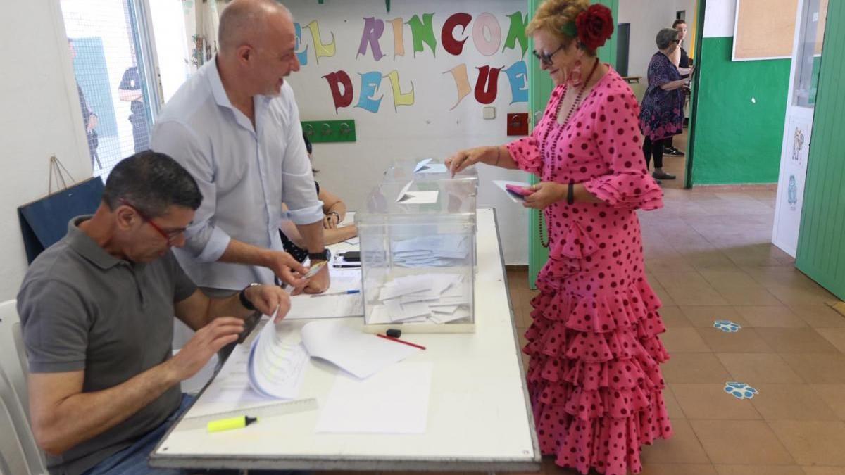 Una mujer vestida de flamenca votando durante las pasadas elecciones municipales.