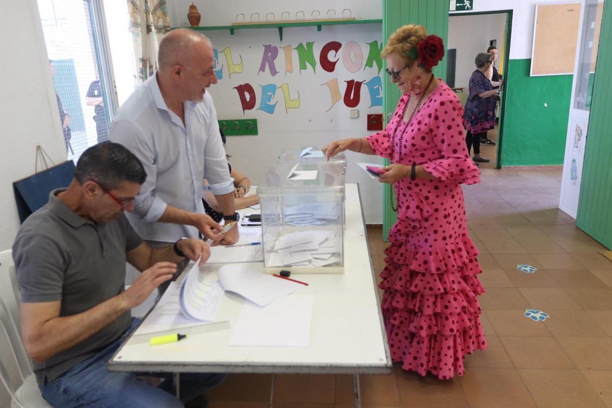 Una mujer vestida de flamenca votando durante las pasadas elecciones municipales.