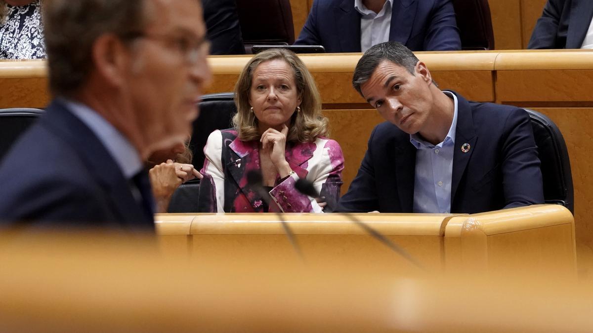 Pedro Sánchez junto a Nadia Calviño en el Senado escuchan a Alberto Núñez Feijóo, de espaldas en la imagen.