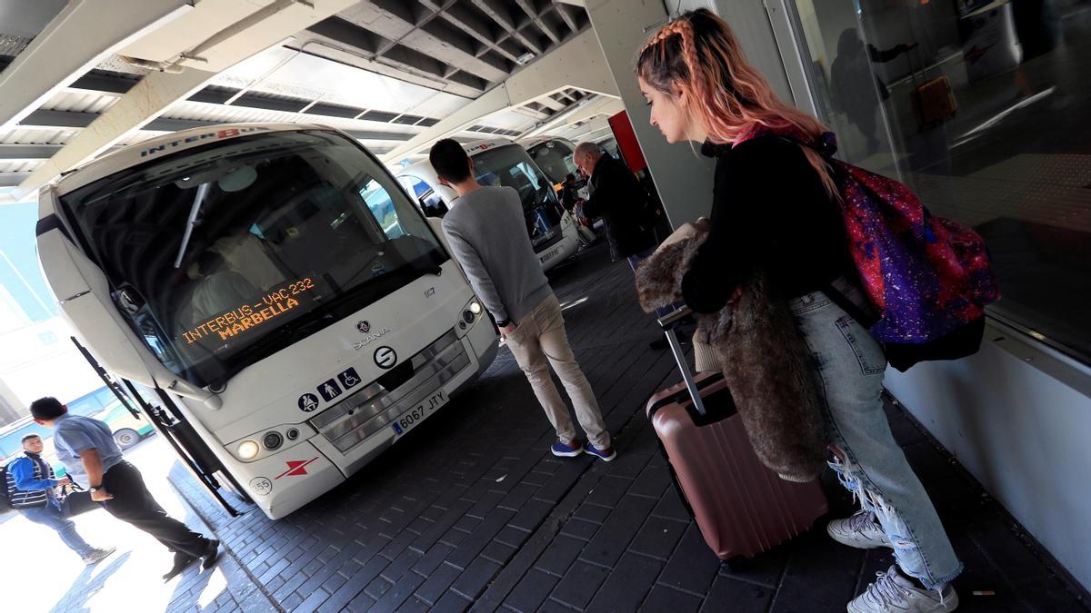 Varias personas esperan a un autobús de línea.