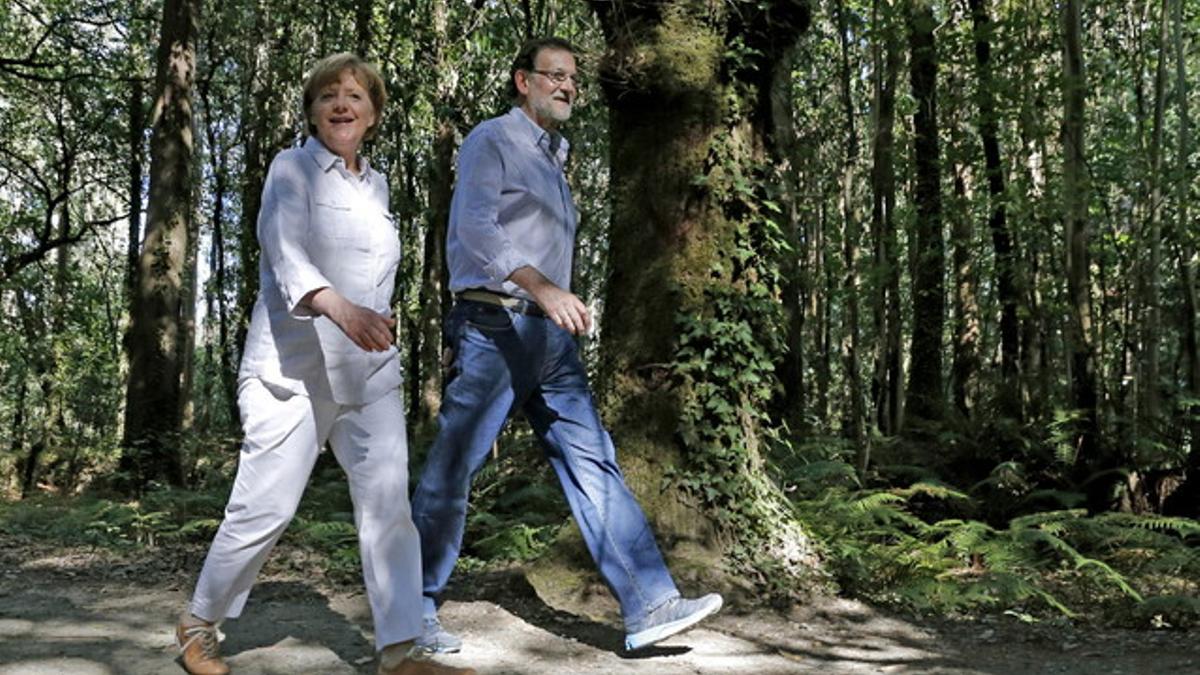 Merkel y Rajoy caminan juntos por el Camino de Santiago.